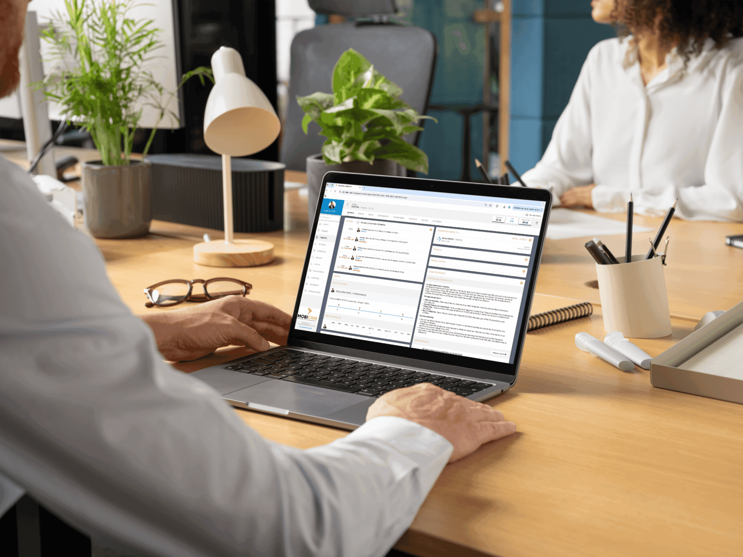 Directeur commercial qui fait une synthèse des comptes rendus de ses commerciaux sur son ordinateur avec l'IA
